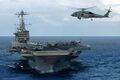 Ветролет MH-60 Seahawk в воздухе на фоне авианосца Nimitz