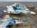 Самолёты Су-25УТГ и Су-33 на технических позициях ТАКР «Адмирал Кузнецов», виден также вертолёт Ка-29