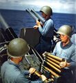 Артиллеристы заряжают обоймы в орудия на линейном крейсере USS Alaska (CB-1) в 1945.