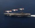 Boeing T-45 Goshawk в полете рядом с авианосцем USS George H.W. Bush