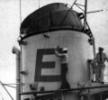 Сейлор рисует «Боевую “Е”» на трубе корабля USS Walker (DDE-517)