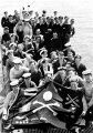 Экипаж и «Веселый Роджер» подводной лодки HMS Trump. На флаге изображен аист с ребенком